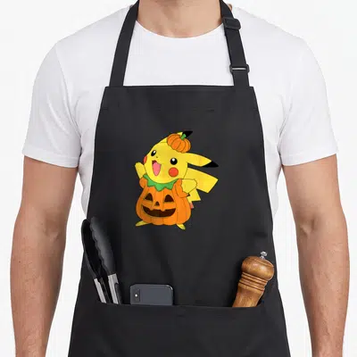 Pumpkin costume halloween kitchen aprons - Yellow cartoon character in orange pumpkin costume with small pumpkin on head — shown on a black cotton canvas apron against a white background