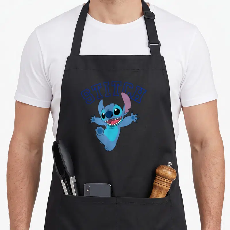 Cute stitch apron - Blue outline STITCH text above a jumping cartoon character on a black background — shown on a black cotton canvas apron against a white background