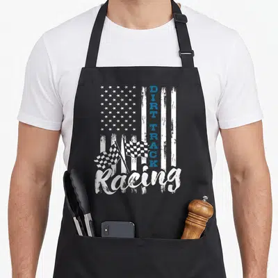 Patriotic track apron - Distressed white and blue flag with vertical DIRT TRACK text, script Racing, and two checkered — shown on a black cotton canvas apron against a white background