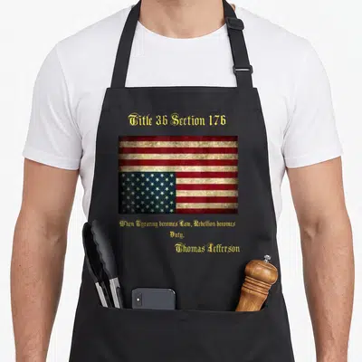 Distress american flag apron - Distressed USA flag with Title 36 Section 176 and Thomas Jefferson quote in gold text — shown on a black cotton canvas apron against a white background
