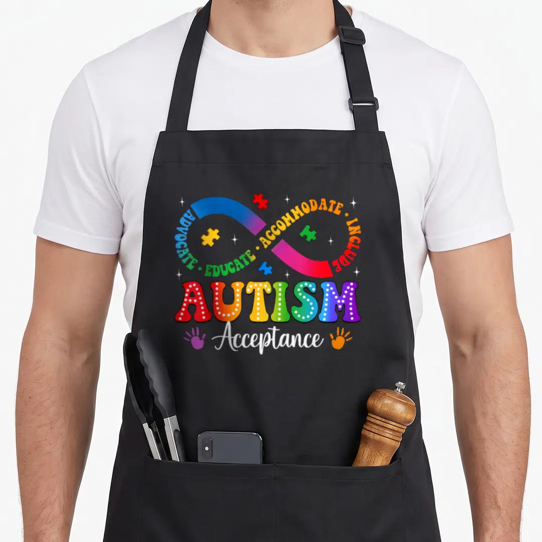 Autism rainbow apron - Rainbow infinity symbol with advocacy text and puzzle pieces — shown on a black cotton canvas apron against a white background