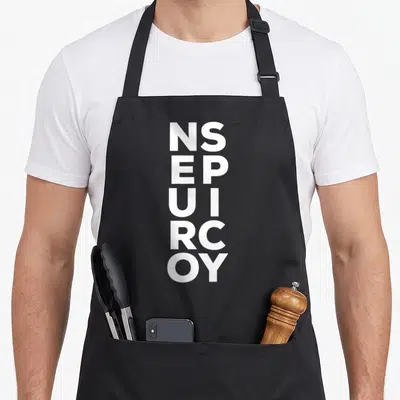 Spectrum neurodivergent apron - White vertical letter stack reading NS EP UI RC OY on grey background — shown on a black cotton canvas apron against a white background