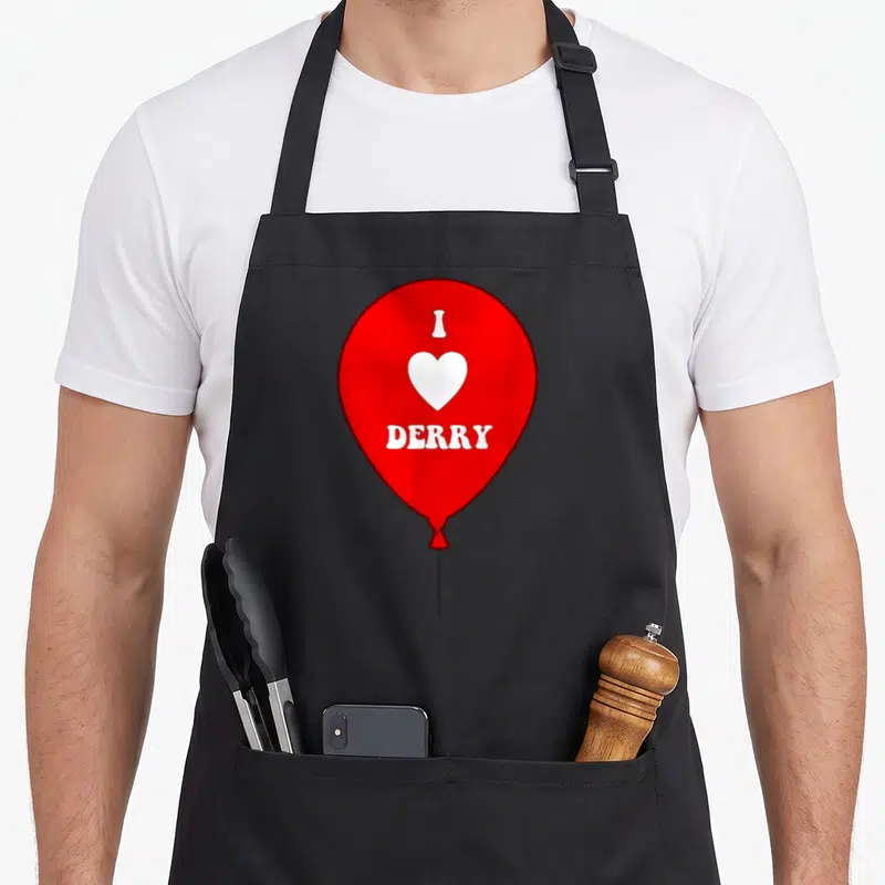 Derry balloon apron - Red balloon with white heart and I DERRY text in minimalist style — shown on a black cotton canvas apron against a white background