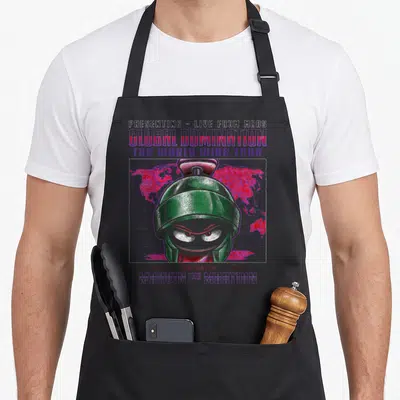 Marvin looney tune apron - Green robot head over red world map and purple grid with presenting live from mars text — shown on a black cotton canvas apron against a white background