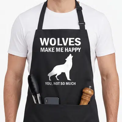 Animal wolves apron - White wolf silhouette between text WOLVES MAKE ME HAPPY YOU NOT SO MUCH — shown on a black cotton canvas apron against a white background