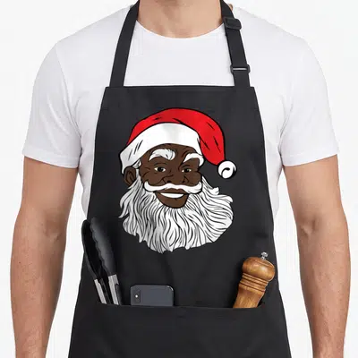 Funny santa african american aprons - Cartoon Black Santa face with red hat, white beard, and brown skin tone — shown on a black cotton canvas apron against a white background