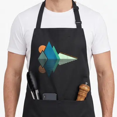 Meant bouldering apron - Geometric mountains in blue teal orange and light green with mirrored stripes and climbing text — shown on a black cotton canvas apron against a white background