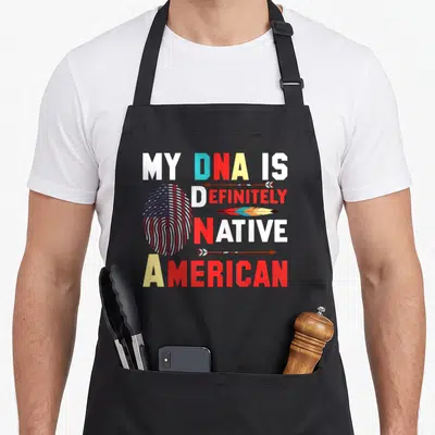 Definitely native american aprons - Stacked text My DNA Is Definitely Native American with flag fingerprint, arrows — shown on a black cotton canvas apron against a white background