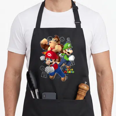 Action donkey apron - Mario Luigi and Donkey Kong cartoon art with question blocks and coins — shown on a black cotton canvas apron against a white background