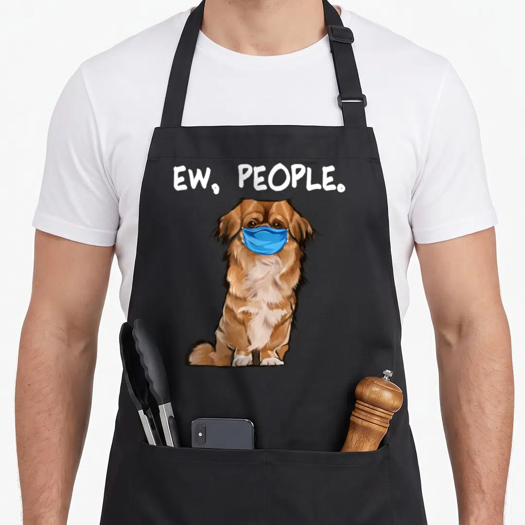 Pekingese dog face apron - Cartoon brown dog wearing a blue mask under white ew people text — shown on a black cotton canvas apron against a white background