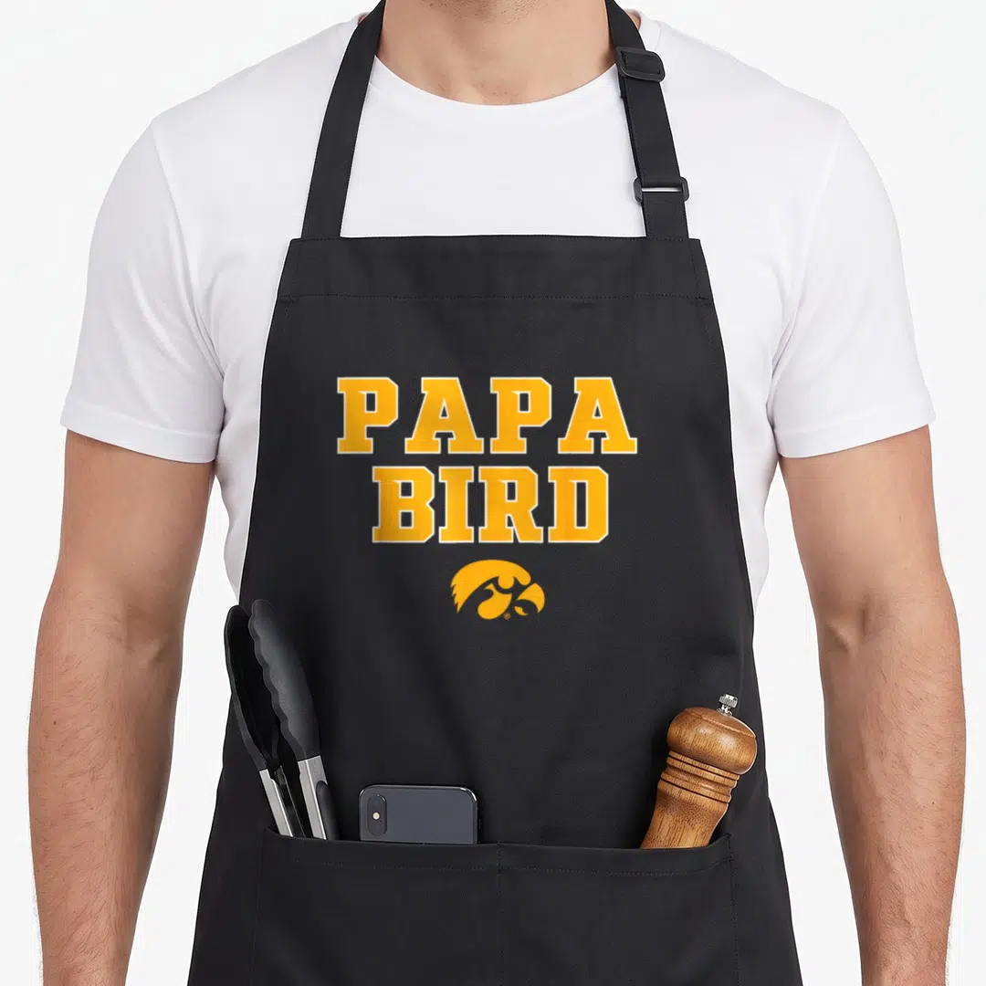 Iowa bird apron - Stacked PAPA BIRD text above yellow bird head logo — shown on a black cotton canvas apron against a white background