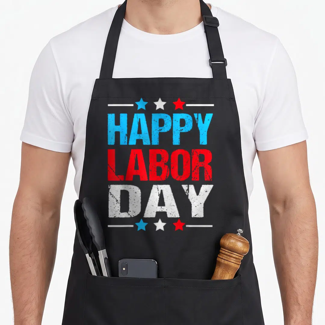 Labor patriots apron - Stacked distressed HAPPY LABOR DAY text in blue red white with three stars and lines — shown on a black cotton canvas apron against a white background