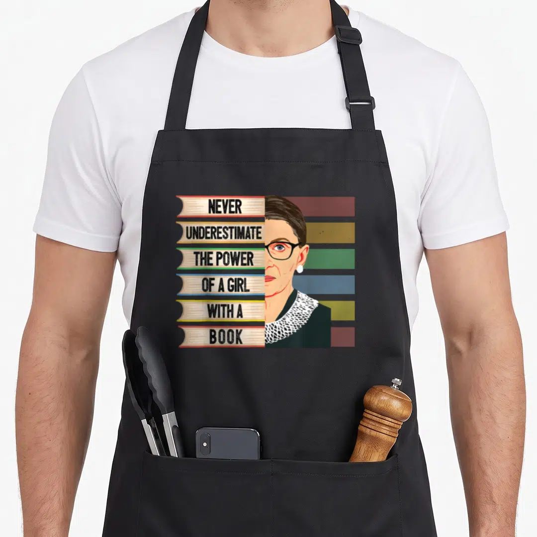 Feminist book apron - Stack of six books with quote and Ruth Bader Ginsburg portrait in minimalist style — shown on a black cotton canvas apron against a white background
