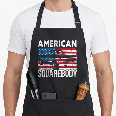 Square body truck apron - AMERICAN SQUAREBODY text over distressed flag and white truck outline — shown on a black cotton canvas apron against a white background