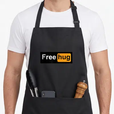 Hug free apron - Black rectangle with white Free text and orange box containing black hug text — shown on a black cotton canvas apron against a white background