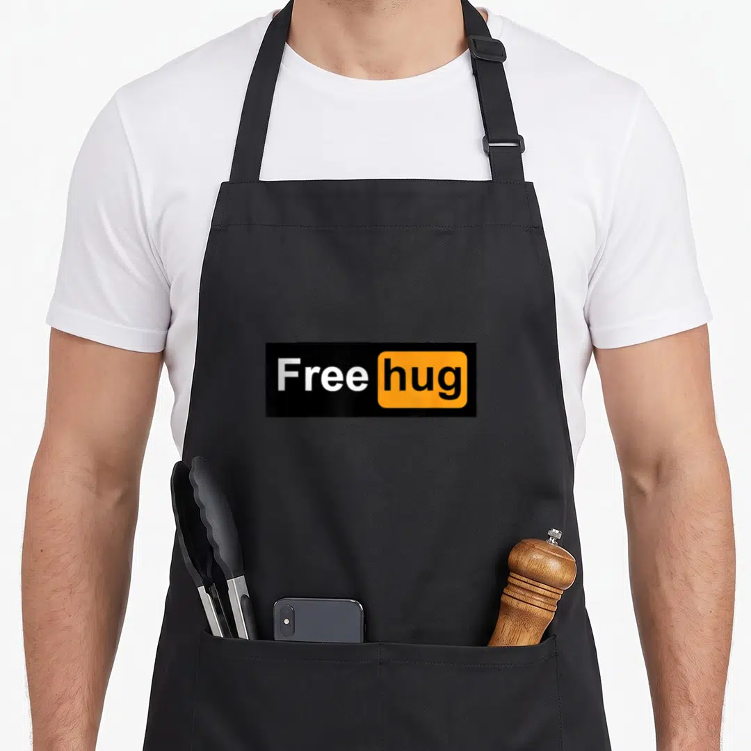 Hug free apron - Black rectangle with white Free text and orange box containing black hug text — shown on a black cotton canvas apron against a white background