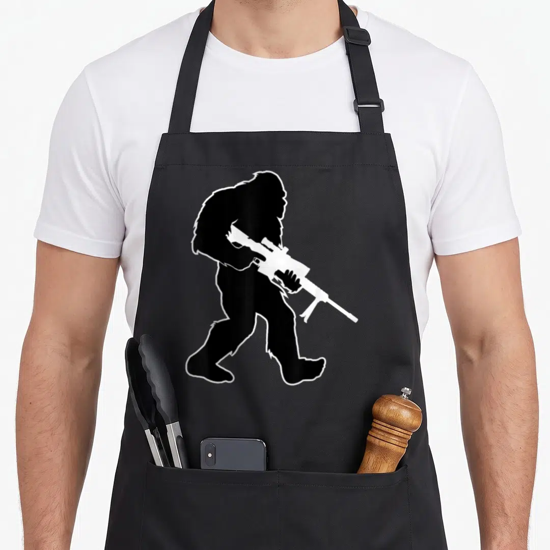 Bigfoot swat bbq apron - Black silhouette of Bigfoot holding a white sniper rifle with white outline — shown on a black cotton canvas apron against a white background