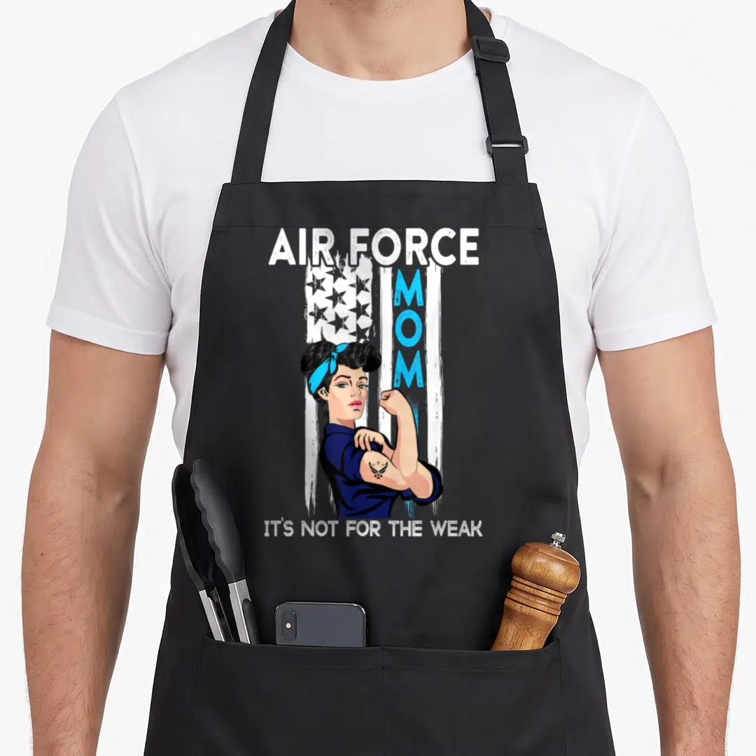 Weak air force mom apron - Cartoon woman flexing arm under AIR FORCE MOM text and stylized flag with blue and white — shown on a black cotton canvas apron against a white background