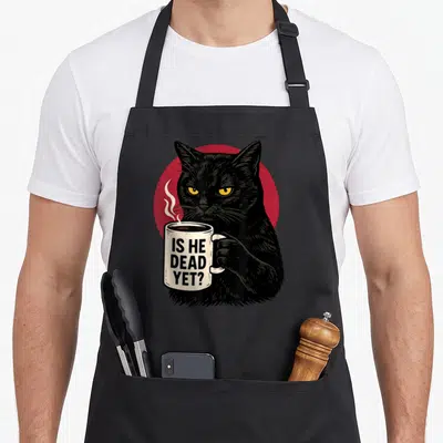 Dead yet dark apron - Black cat holding white mug with IS HE DEAD YET text in front of red circle — shown on a black cotton canvas apron against a white background