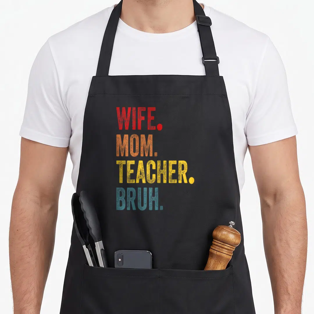 Bruh best teacher apron - Stacked WIFE. MOM. TEACHER. BRUH. text in red, orange, yellow, and blue block letters — shown on a black cotton canvas apron against a white background