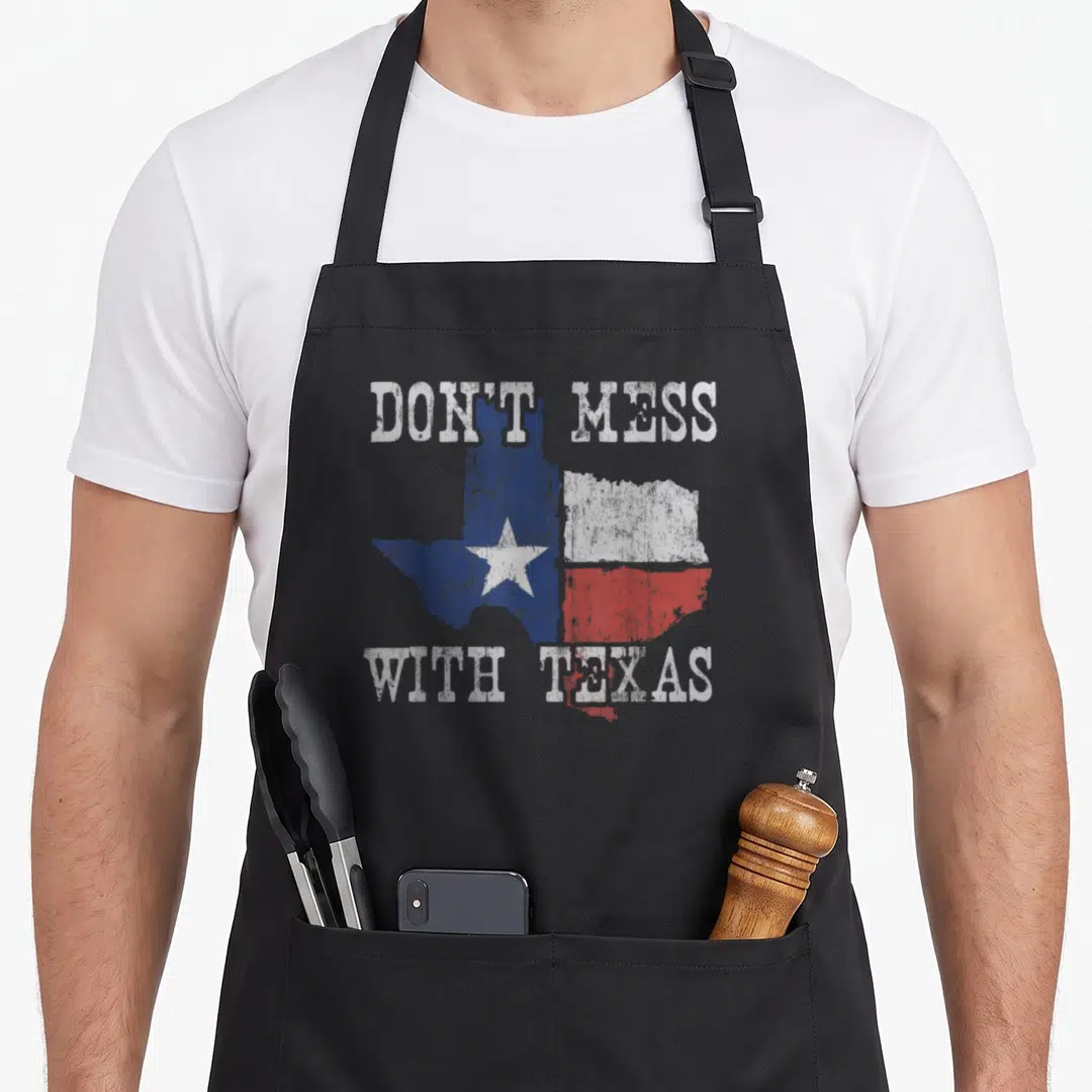 Mess texas longhorn apron - Distressed map of Texas filled with flag colors and text Don't Mess With Texas — shown on a black cotton canvas apron against a white background