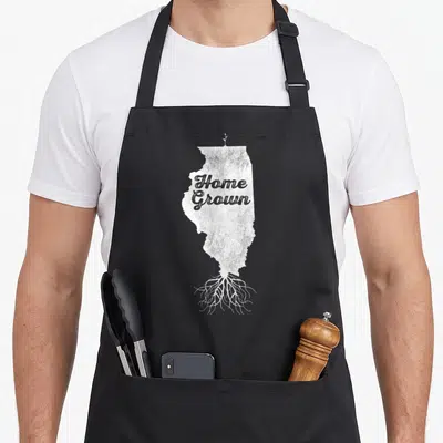 Silhouette pride apron - White Illinois map silhouette with Home Grown text, top sprout and bottom roots in distressed — shown on a black cotton canvas apron against a white background