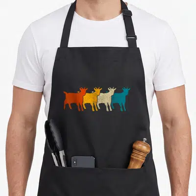 Goat animal farm aprons - Four retro goat silhouettes in orange, yellow, beige, and teal arranged horizontally — shown on a black cotton canvas apron against a white background
