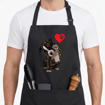 Five boxer dog apron - Cartoon brown boxer dog raising paw beside red heart with paw print — shown on a black cotton canvas apron against a white background