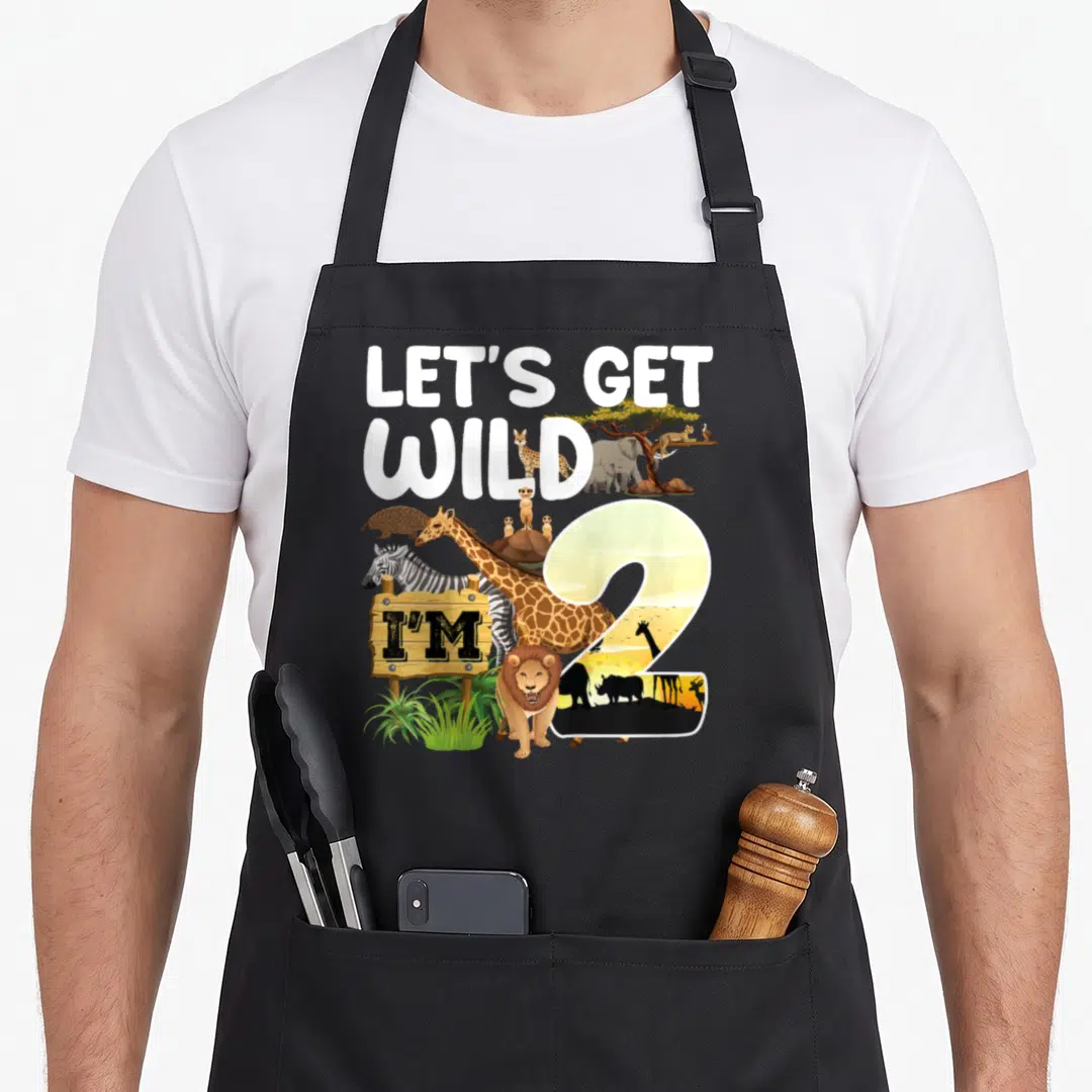 Jungle 2nd apron - Cartoon giraffe zebra lion and number 2 with text LETS GET WILD IM — shown on a black cotton canvas apron against a white background