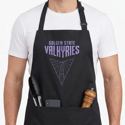 Wnba golden apron - GOLDEN STATE VALKYRIES text in light purple with dotted downward triangle, typography only — shown on a black cotton canvas apron against a white background