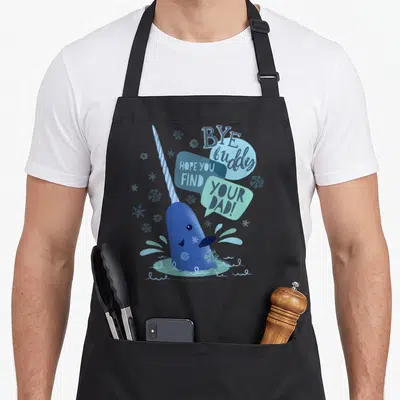 Narwhal elf apron - Blue cartoon narwhal with speech bubbles reading Bye buddy hope you find your dad surrounded — shown on a black cotton canvas apron against a white background