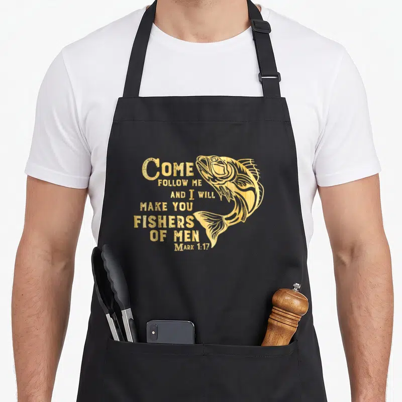 Fisher christian apron - Gold fish illustration next to stacked Mark 1:17 Bible verse text — shown on a black cotton canvas apron against a white background