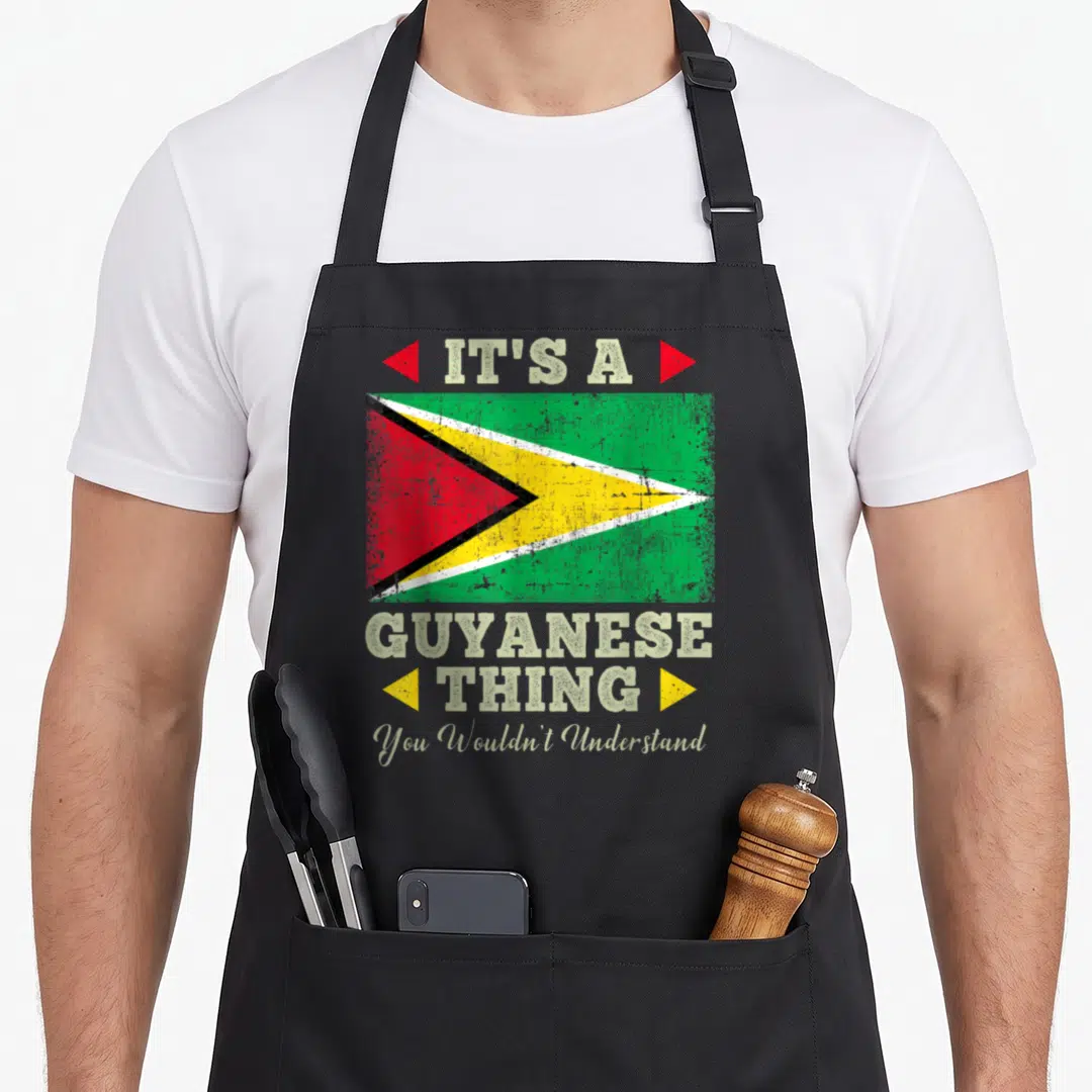 Guyanese guyana apron - Distressed Guyana flag with stacked text IT'S A GUYANESE THING flanked by triangles on grey — shown on a black cotton canvas apron against a white background