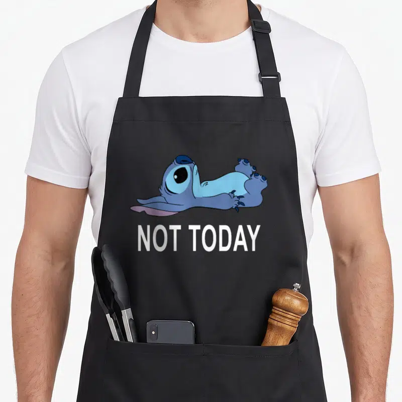 Today stitch apron - Blue cartoon character lying down above white NOT TODAY text — shown on a black cotton canvas apron against a white background