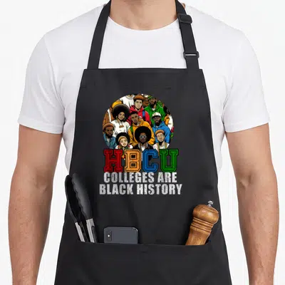 History college apron - Cartoon oval of students above HBCU text in red yellow blue and green on black fabric — shown on a black cotton canvas apron against a white background