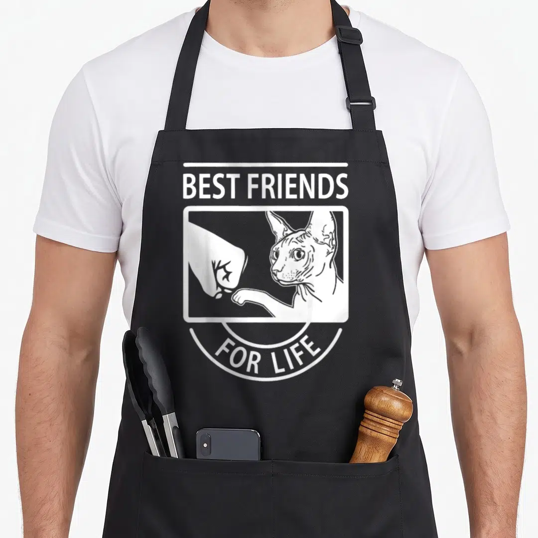 Sphynx friend cat apron - White line-art of cat and hand fist bumping with best friends for life text on grey background — shown on a black cotton canvas apron against a white background