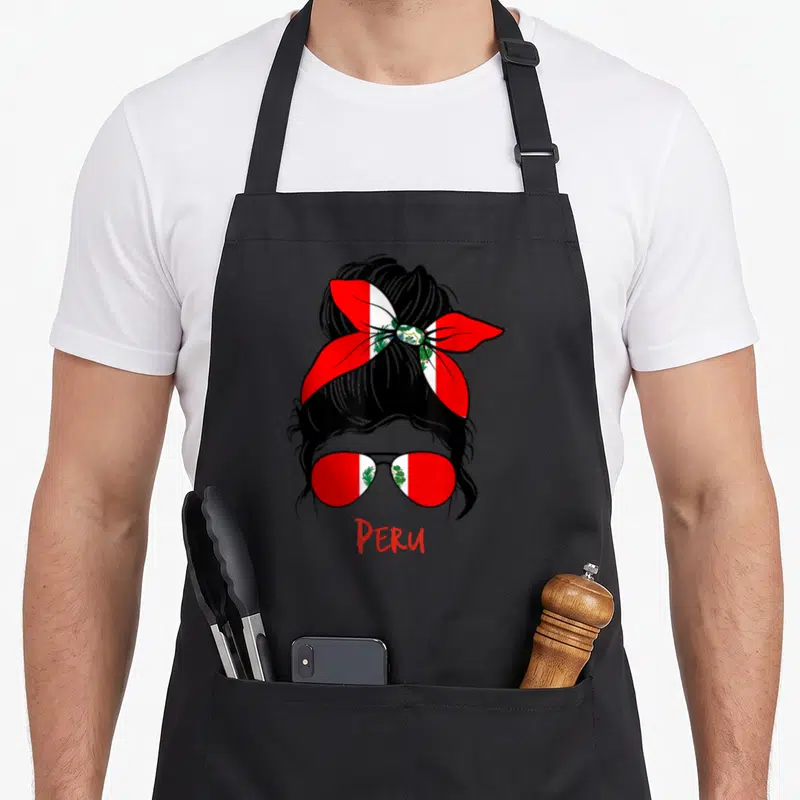 Peru messy aprons - Stylized messy bun with flag bow, sunglasses, and PERU text — shown on a black cotton canvas apron against a white background