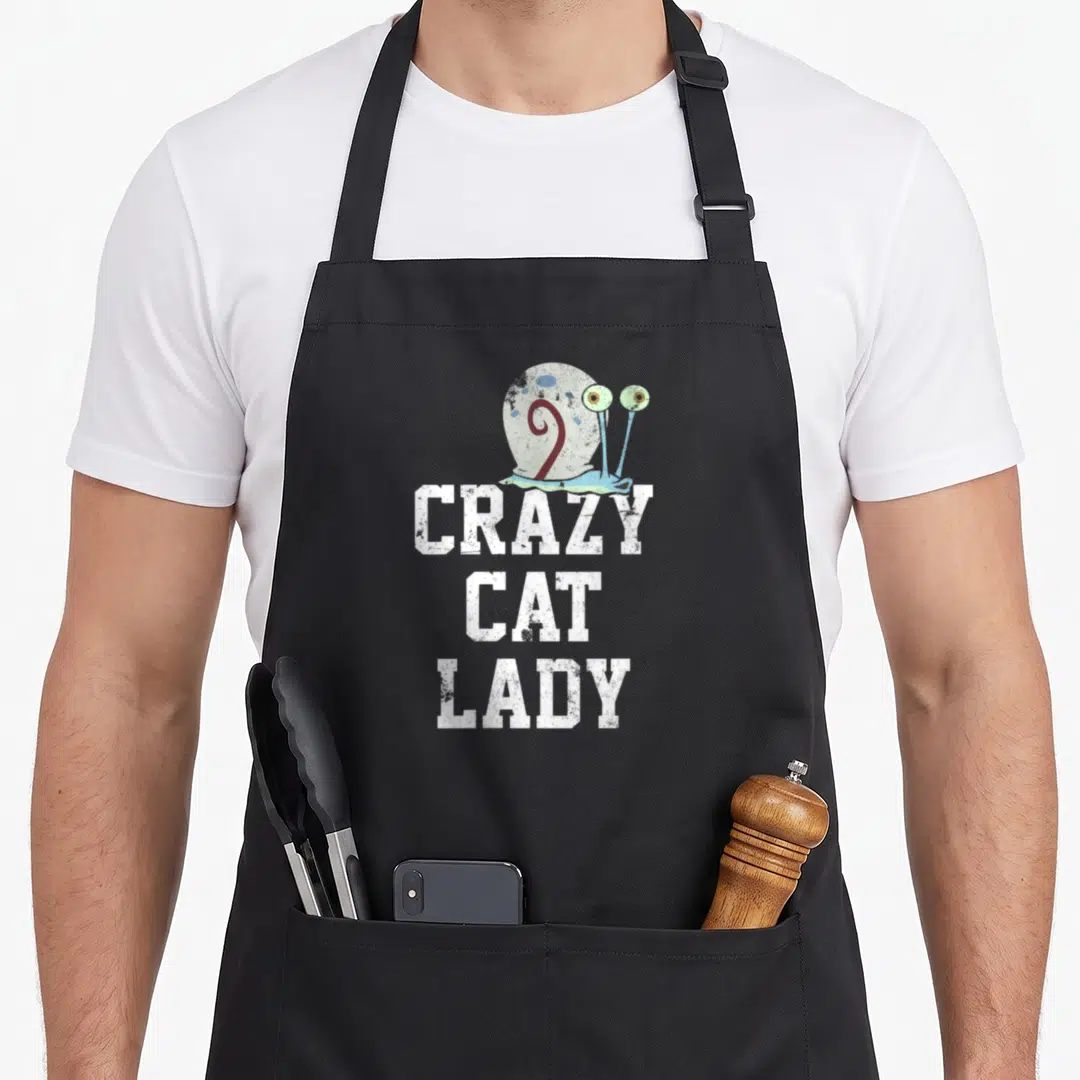 Gary crazy cat lady apron - Distressed snail above white stacked text CRAZY CAT LADY on black fabric — shown on a black cotton canvas apron against a white background