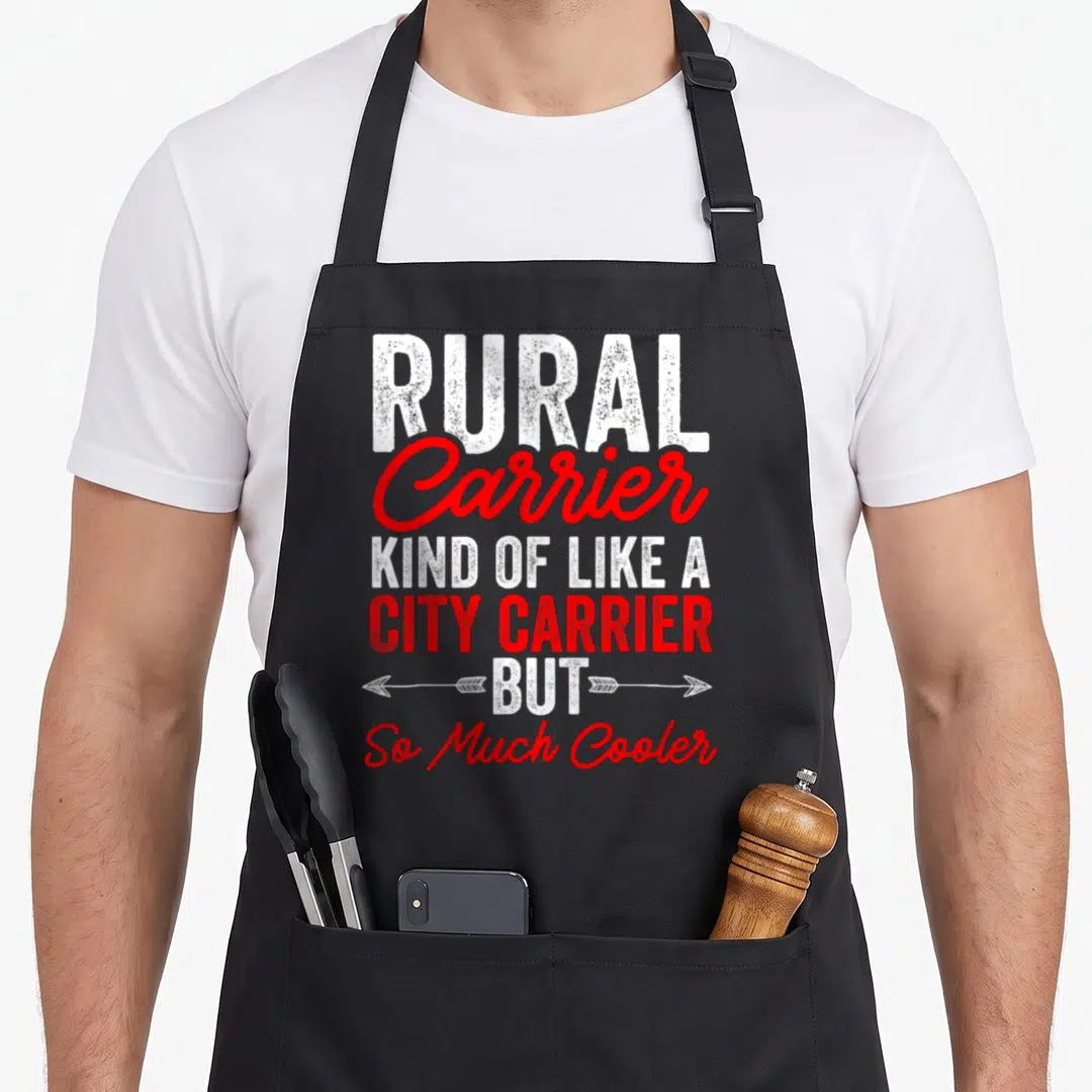Postman rural apron - Stacked white and red text reading Rural Carrier Kind Of Like A City Carrier But So Much Cooler — shown on a black cotton canvas apron against a white background