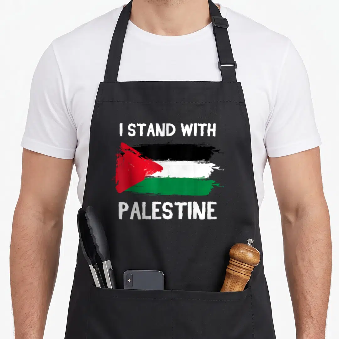 Pendant palestine apron - Distressed brush stroke flag in white black green and red with white text I STAND — shown on a black cotton canvas apron against a white background