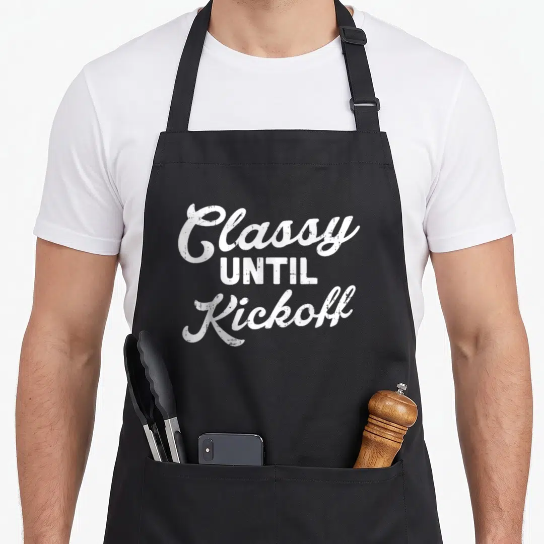 Kickoff football apron - White distressed text reading Classy UNTIL Kickoff stacked vertically — shown on a black cotton canvas apron against a white background