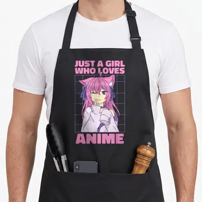 Cute otaku anime apron - Pink text reading Just A Girl Who Loves Anime above and below a winking catgirl on a purple — shown on a black cotton canvas apron against a white background