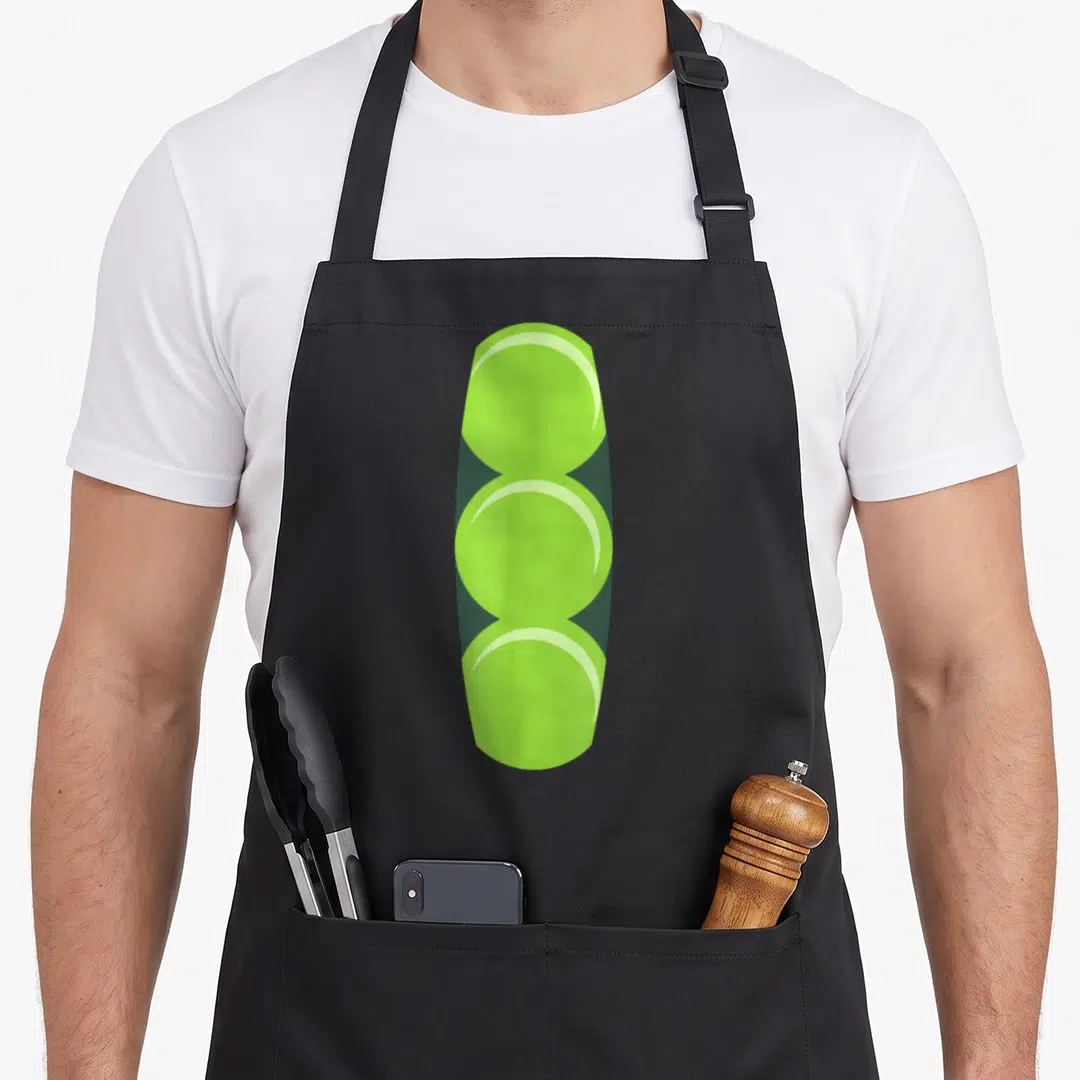 Pod halloween apron - Three lime green circles stacked vertically representing peas in a pod — shown on a black cotton canvas apron against a white background