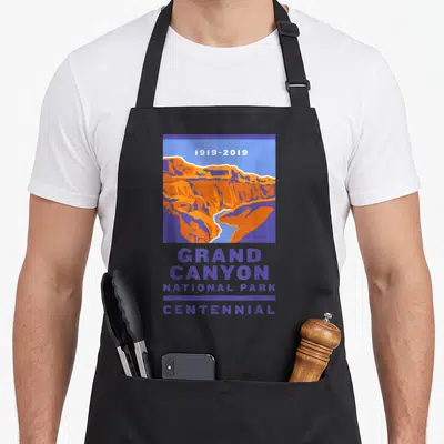 National grand canyon apron - 1919-2019 GRAND CANYON NATIONAL PARK CENTENNIAL text with purple orange blue canyon — shown on a black cotton canvas apron against a white background
