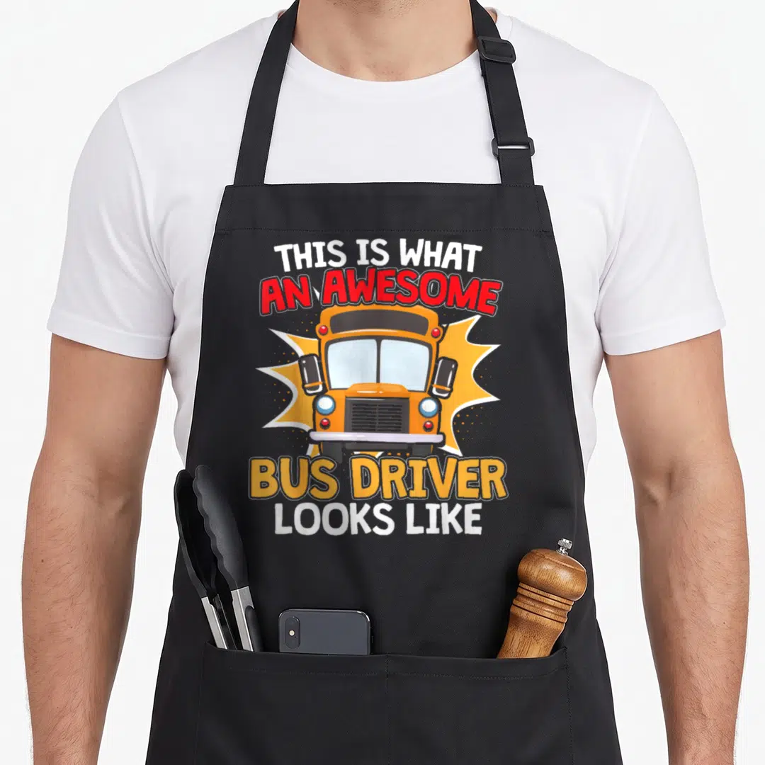 School appreciation bus driver apron - Cartoon orange school bus front view with bold text on jagged background — shown on a black cotton canvas apron against a white background