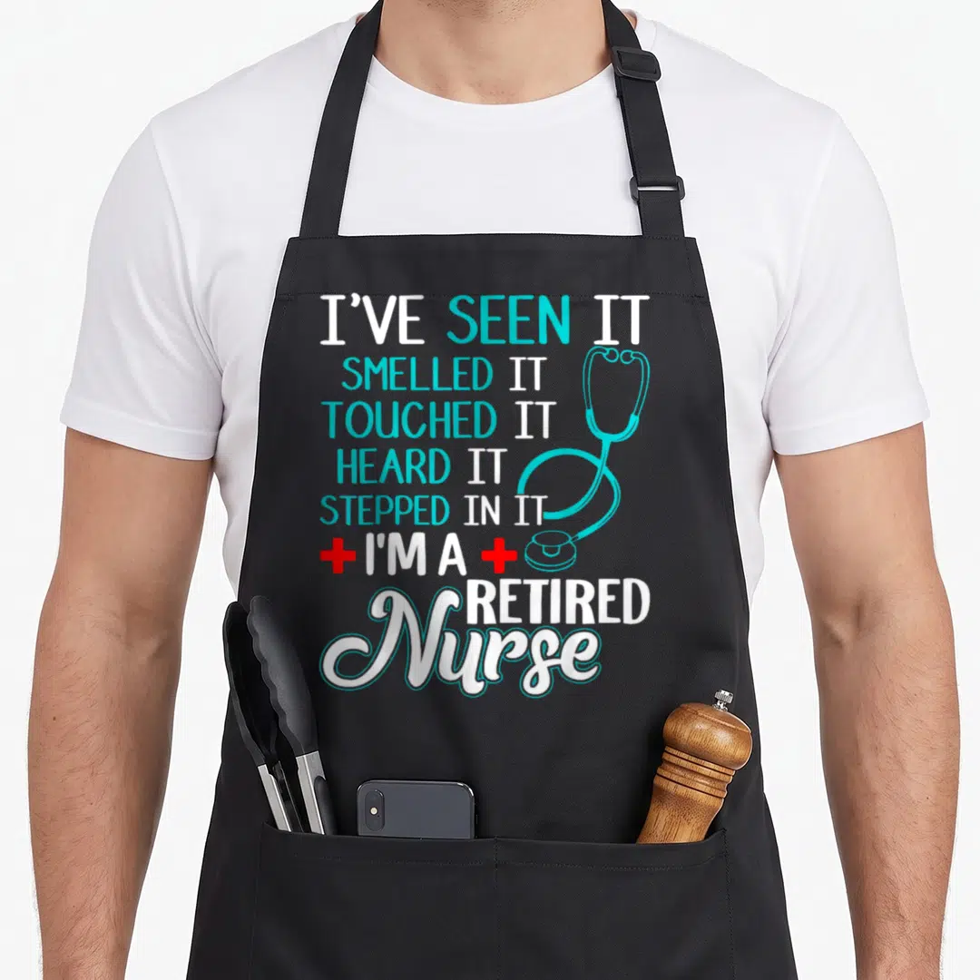 Retirement nurse apron - Stacked white and teal text with teal stethoscope and two red crosses flanking I'm — shown on a black cotton canvas apron against a white background