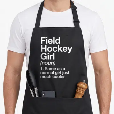 Field sassy apron - White text reading Field Hockey Girl noun definition on black background — shown on a black cotton canvas apron against a white background