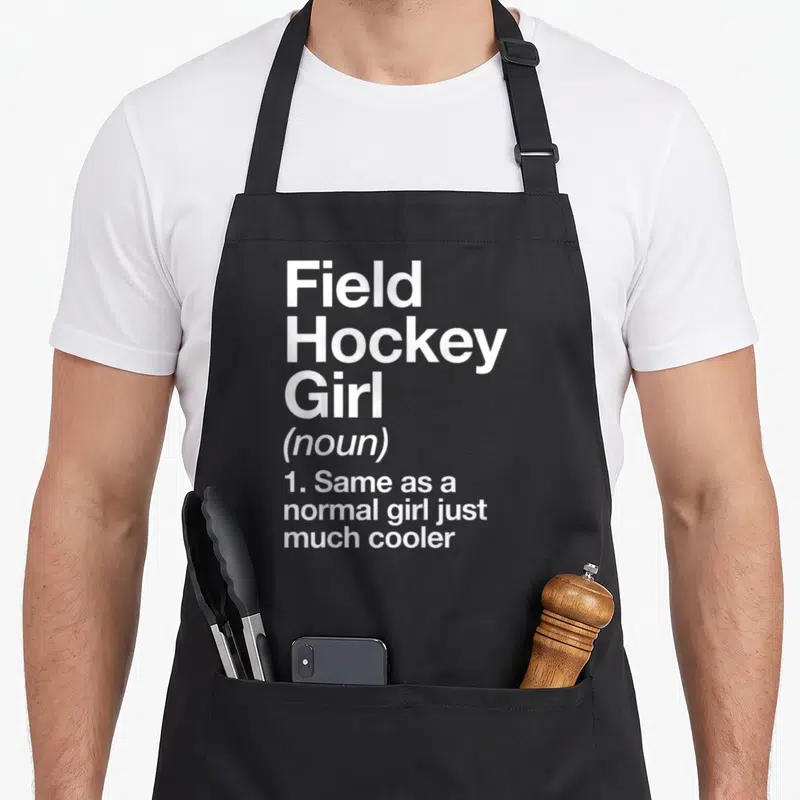 Field sassy apron - White text reading Field Hockey Girl noun definition on black background — shown on a black cotton canvas apron against a white background