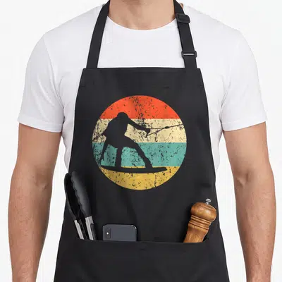 Wakeboarder wakeboarding apron - Grey wakeboarder silhouette holding a rope inside a red beige teal and yellow striped — shown on a black cotton canvas apron against a white background