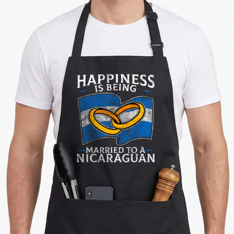 Nicaraguan wedding apron - Two interlocking gold rings on a blue and white striped flag with distressed text — shown on a black cotton canvas apron against a white background